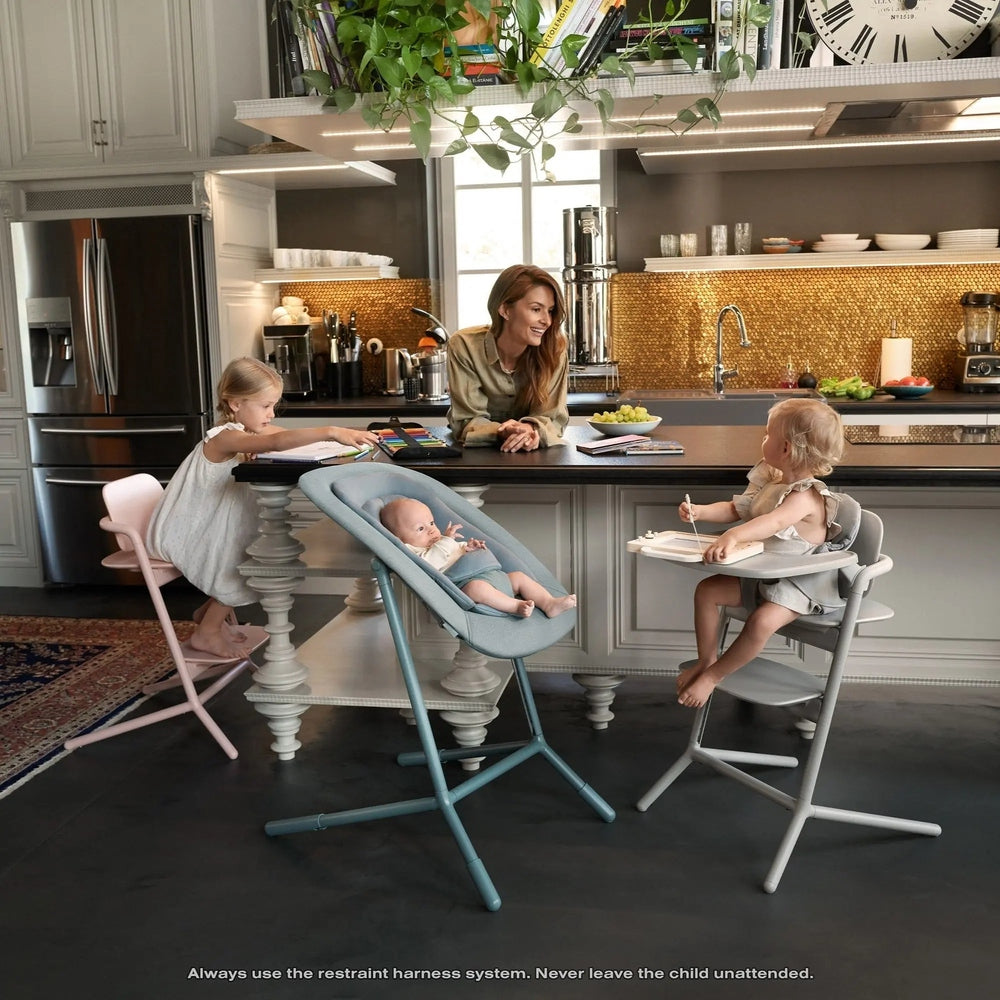 Lifestyle image of the Cybex Lemo 2 High Chair 3-In-1 Set in gray, baby securely seated at the island while siblings join mealtime.