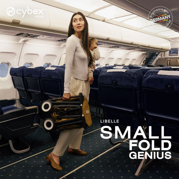 Cybex Libelle Ultra-compact Stroller in Cinnamon Yellow folded beside a traveller in an airplane aisle