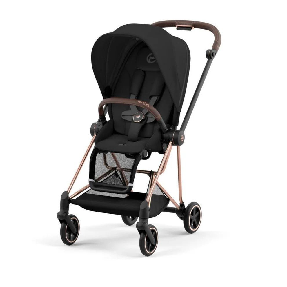 Lifestyle image of the Cybex Mios 3 Stroller (One Box) Rose Gold Frame in black with canopy, storage basket, and push-ready stance.