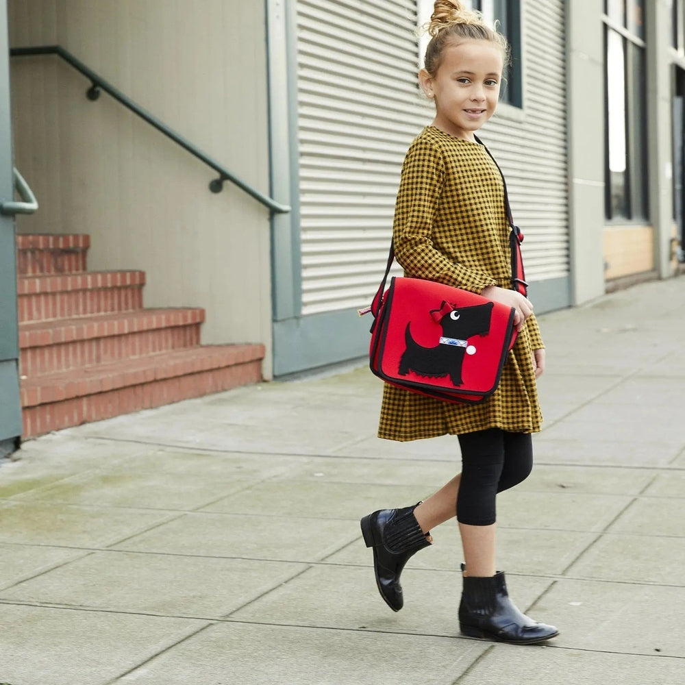 Dabbawalla Machine Washable Messenger Bag in red, worn crossbody by a girl, with a black dog motif.