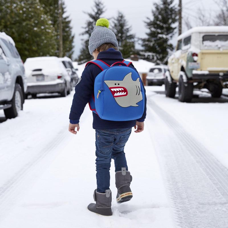 Dabbawalla Toddler Backpack Shark Tank blue with shark graphic worn by a child walking on a snowy street