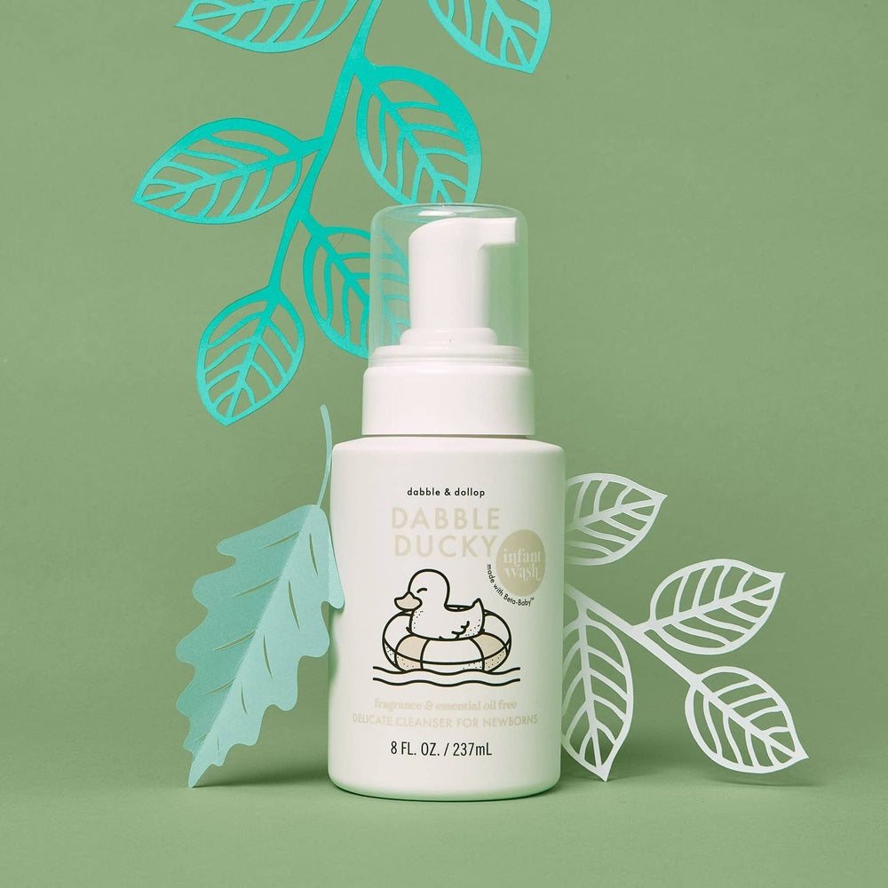 Dabble & Dollop All-Natural Infant Wash Fragrance Free bottle with pump on a green leafy backdrop.