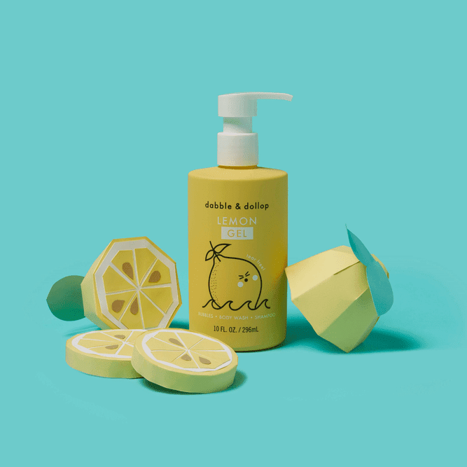 Dabble & Dollop All-Natural Shampoo, Body Wash & Bubbles Lemon with pump, bright yellow bottle beside lemon props.
