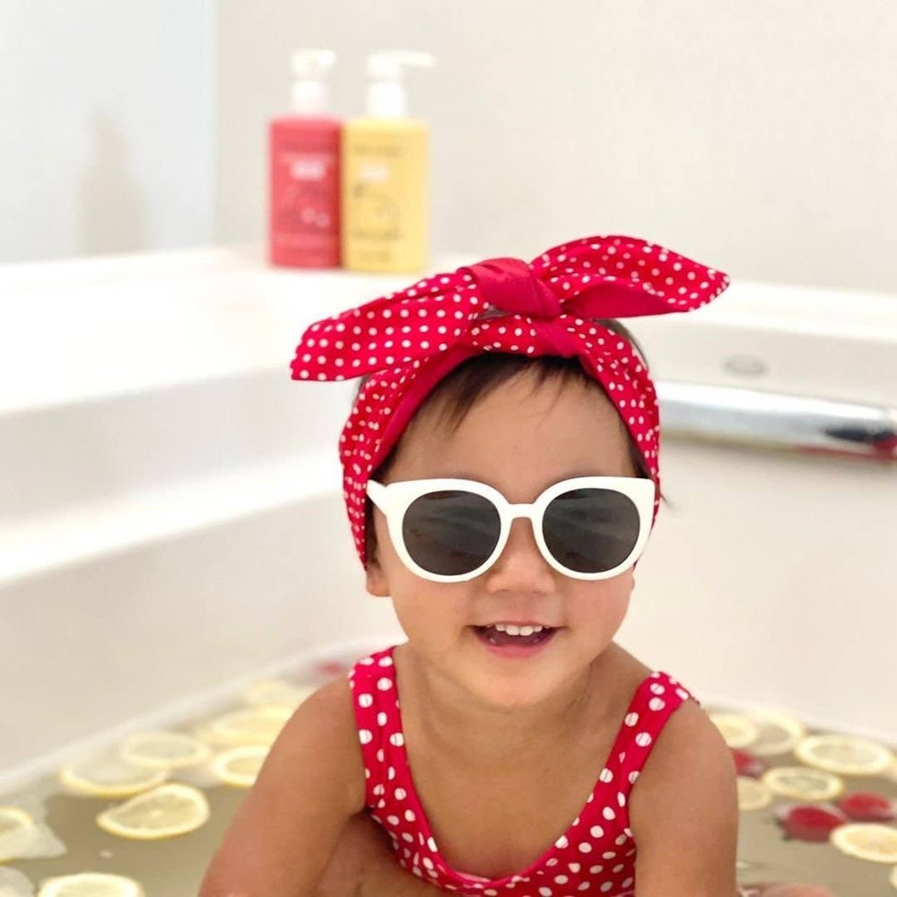 Dabble & Dollop All-Natural Shampoo, Body Wash & Bubbles Lemon-child bath time with lemon slices, red polka-dot headband, white sunglasses