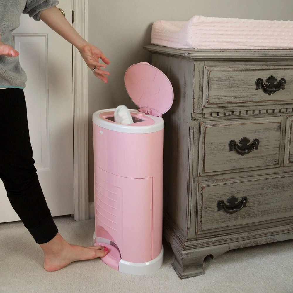 Dekor Plus Diaper Pail in pink with white rim, open lid shown as a parent uses the foot pedal.