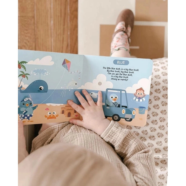 Ditty Bird Sound Book Color Songs USB-C Rechargeable used by a toddler turning blue vehicle pages.