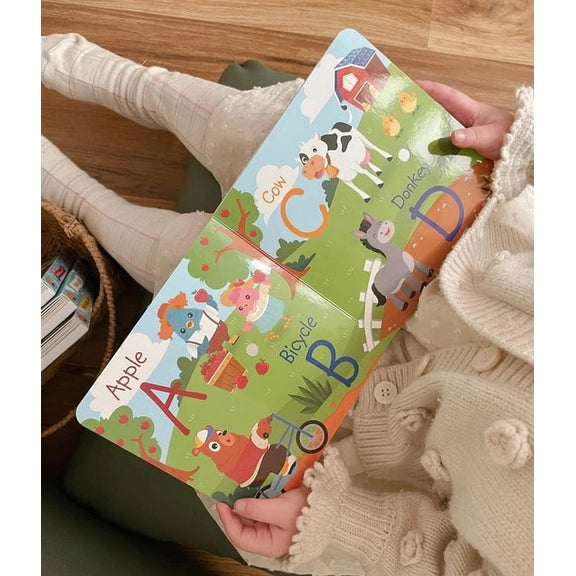 Ditty Bird Sound Book Fun Alphabet USB-C Rechargeable; a child holds and opens the colorful alphabet book with animal illustrations.