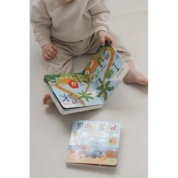 Ditty Bird Sound Book Fun Alphabet USB-C Rechargeable; baby explores a colorful interactive book on the floor.