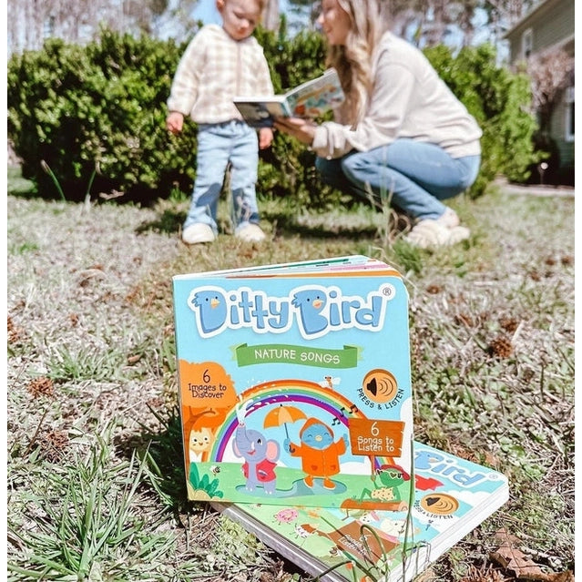 Ditty Bird Sound Book Nature Songs USB-C Rechargeable; mom reads with toddler outdoors, showcasing the cover and audio feature.