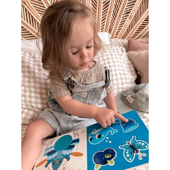 Ditty Bird Sound Book Touch the Colors USB-C Rechargeable; toddler points to colorful pages.