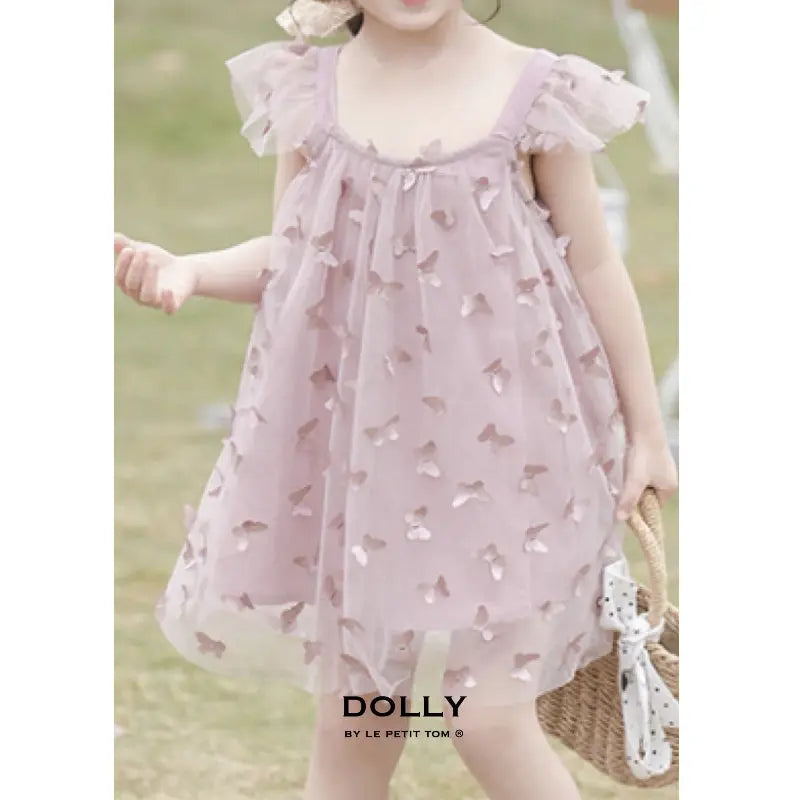 Dolly By Le Petit Tom Allover Butterflies Tutu Dress Mauve Pink, toddler twirling outdoors to show butterfly appliques.