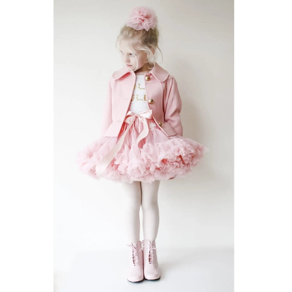 Dolly by Le Petit Tom Queen of Roses Pettiskirt in rose pink; a girl twirls, showing fluffy tulle layers and bow.