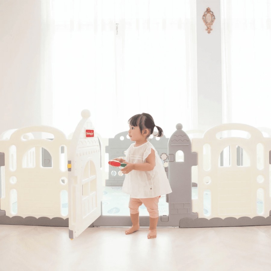 Dwinguler Castle Extension Set Downy Grey play yard with a toddler inside the gate