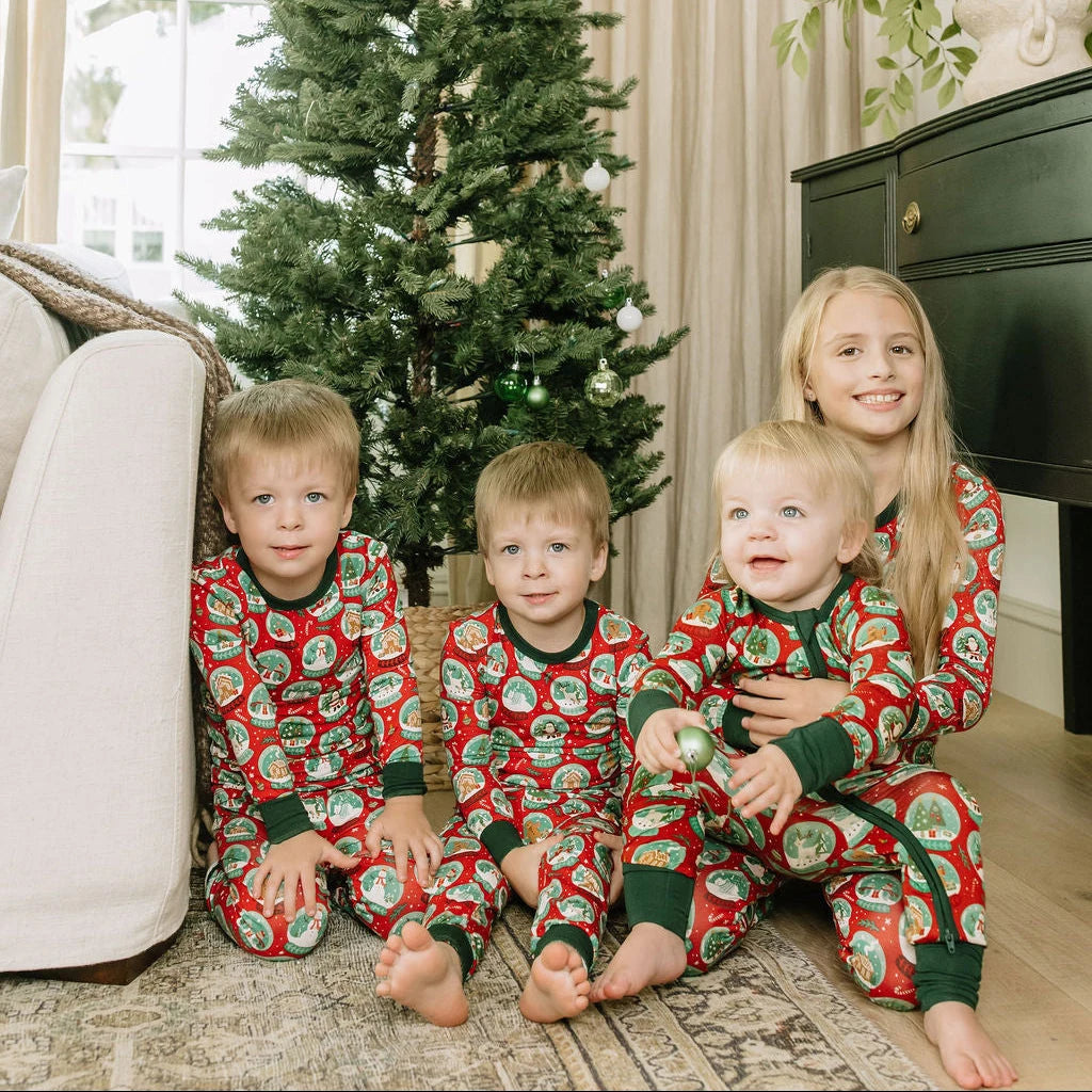 Emerson and Friends Let It Snow kids bamboo pajamas, children wearing coordinating snow-globe sleepwear beside a Christmas tree
