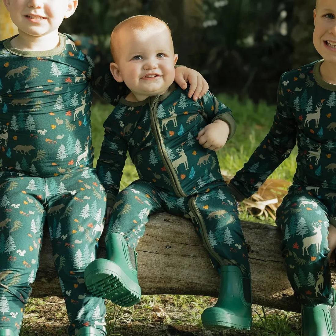 Baby wearing the Midnight Forest Bamboo Convertible Footie Romper outdoors among greenery