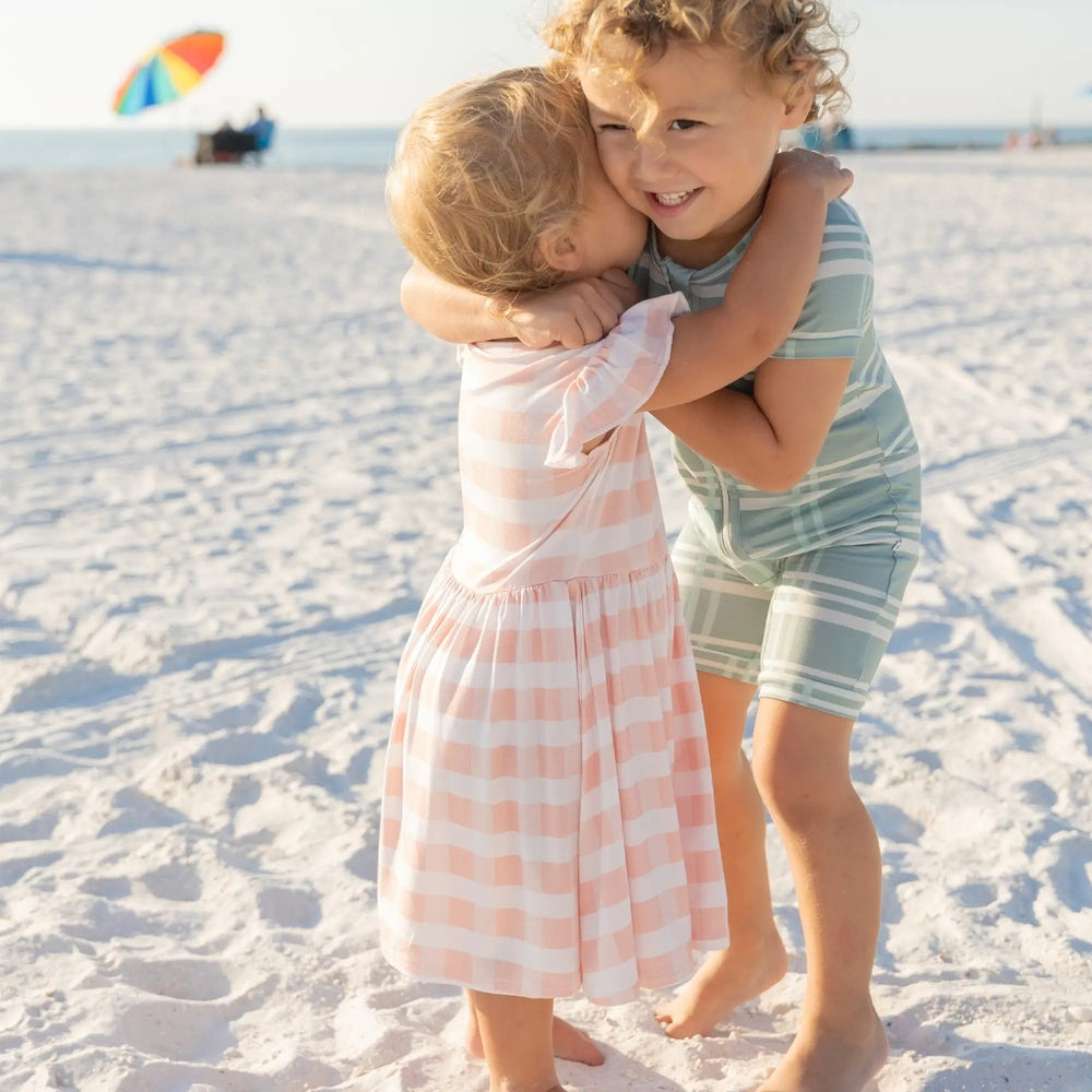 Girls short sleeve bamboo twirl dress featuring a classic pink and white gingham checkered pattern.