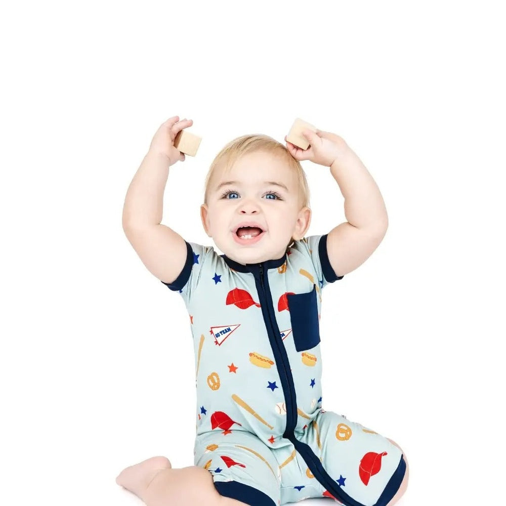 Baby wearing a colorful onesie with various patterns on a white background