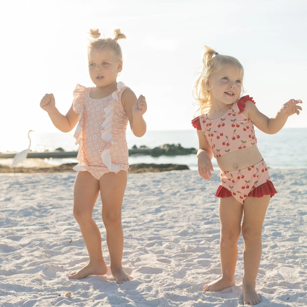 Two-piece swimsuit with cherry pattern on a white background