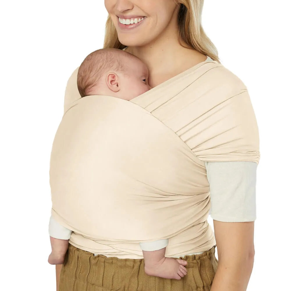 Ergobaby Aura Baby Wrap in beige sustainable knit, baby carried chest-to-chest on parent