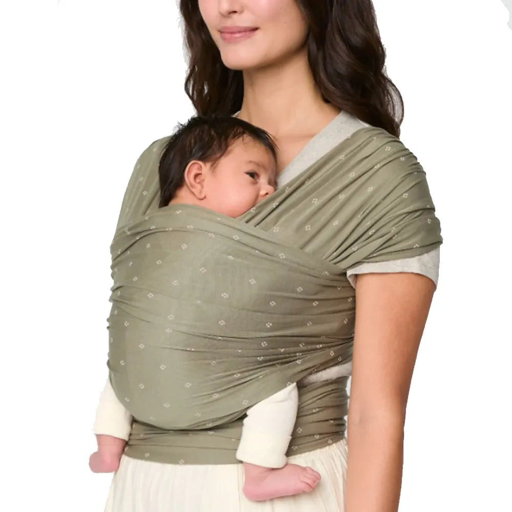 ERGOBABY Aura baby wrap in olive sustainable knit with subtle print, worn by mother carrying baby.