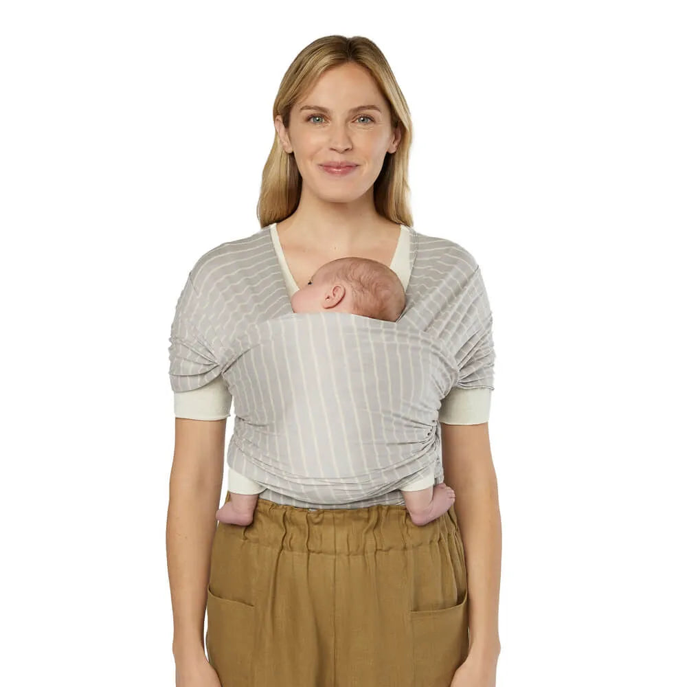 Ergobaby Aura baby wrap carrier in sustainable knit, gray striped fabric, worn by mother with newborn