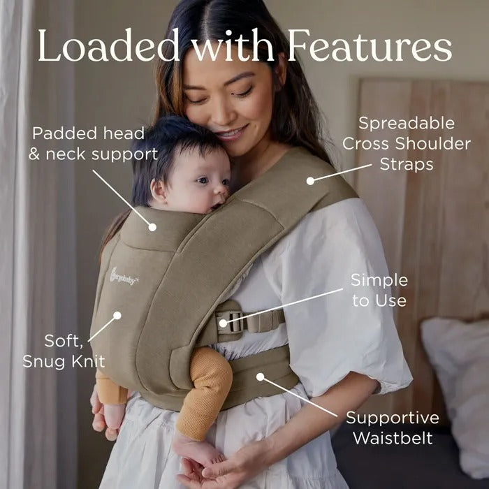 Ergobaby Embrace Knit Newborn Carrier Sage Meadows worn by mom with baby, showing padded head support, soft knit, and cross-shoulder straps.
