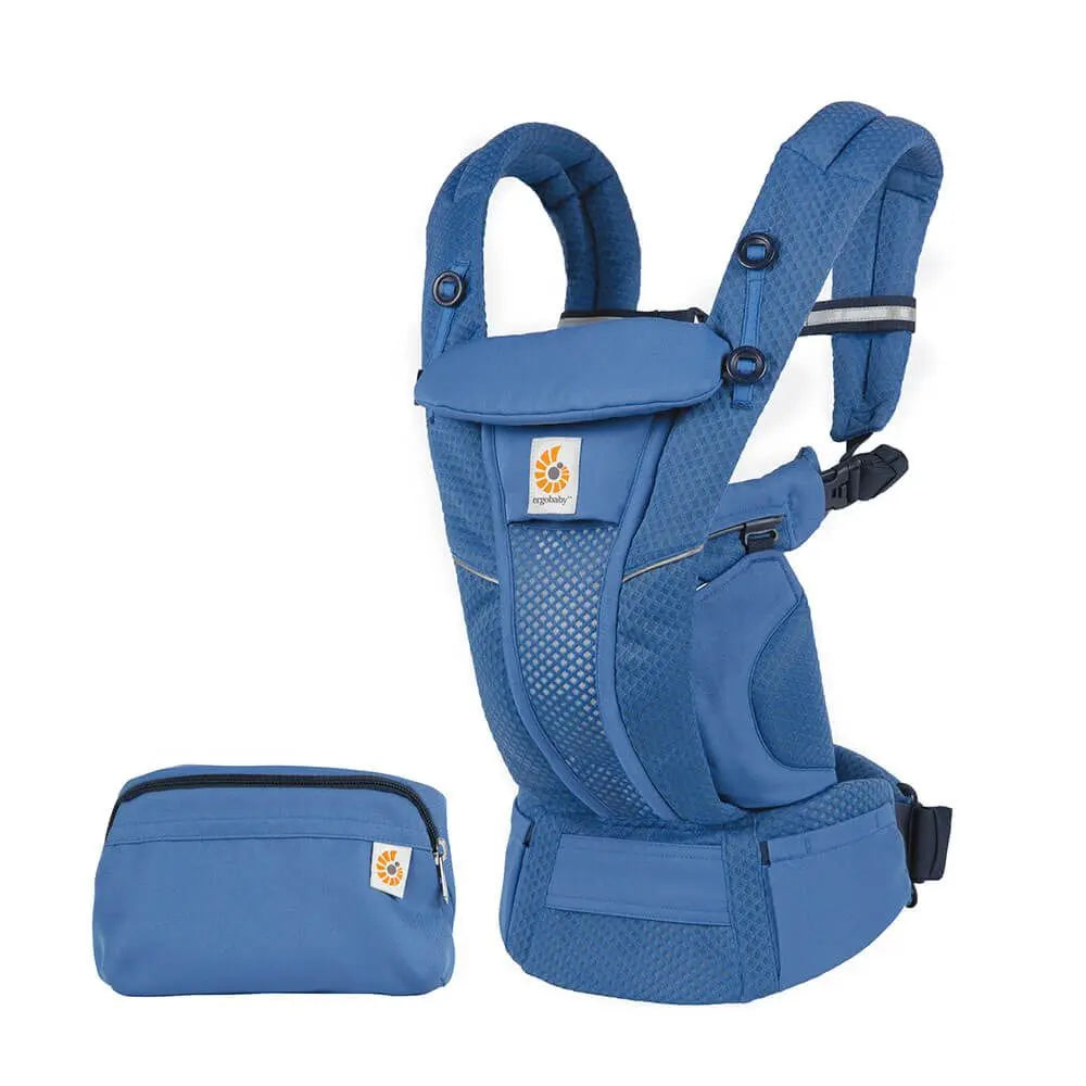 Ergobaby Omni Breeze blue baby carrier worn on a parent's torso with padded straps and waist belt, plus matching pouch.