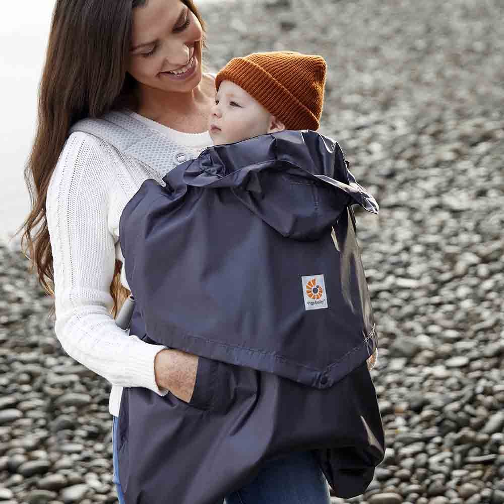 ERGOBABY Rain and Wind Carrier Cover in charcoal; protective baby carrier cover worn by mom outdoors.