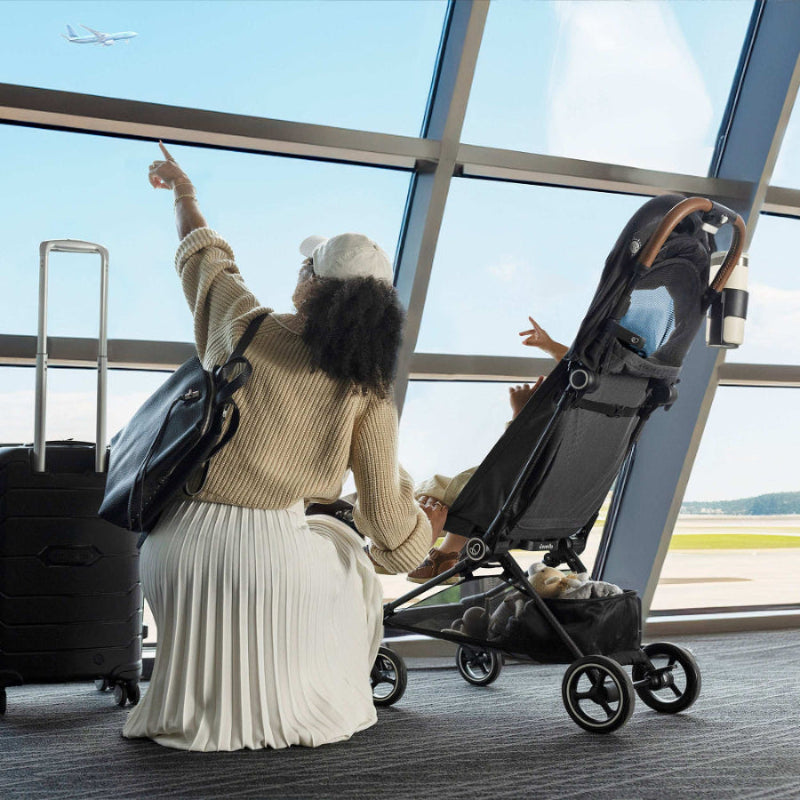 Evenflo Hummingbird Ultra-Lightweight Carbon Fiber Stroller at the airport with luggage in tow