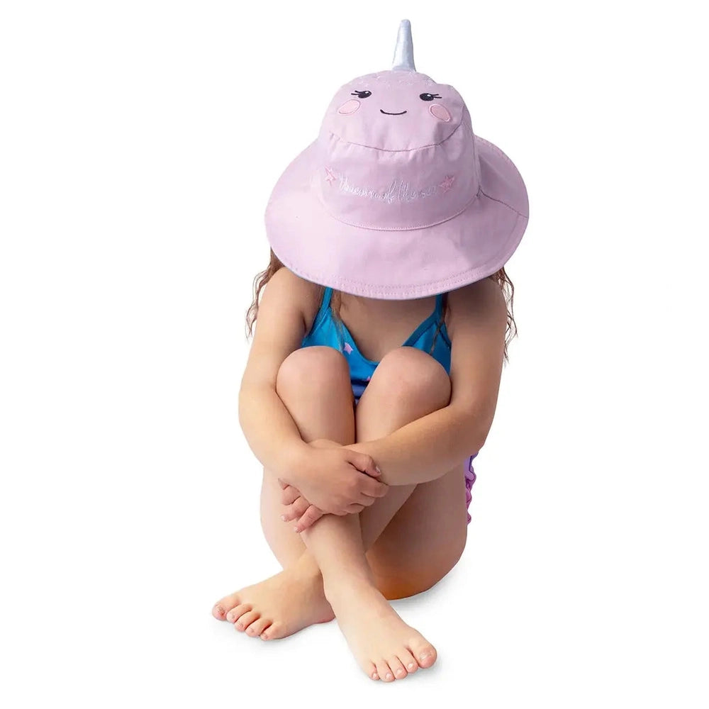 Flapjackkids Reversible Kids Sun Hat Narwhal & Starfish in pink, child seated with brim shielding face.