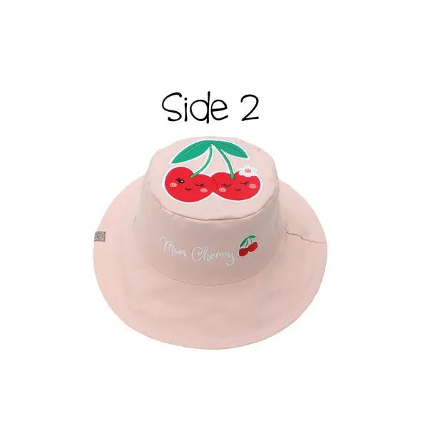 Flapjackkids Reversible Kids Sun Hat, pink with smiling cherry graphic, shown on pink exterior.
