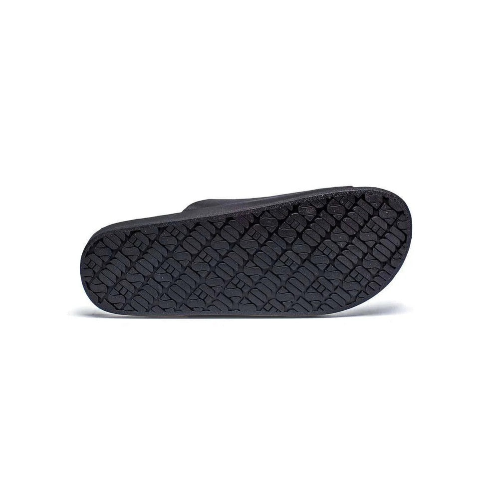Freedom Moses Basic Black slippers showing textured black rubber sole with chunky tread pattern.
