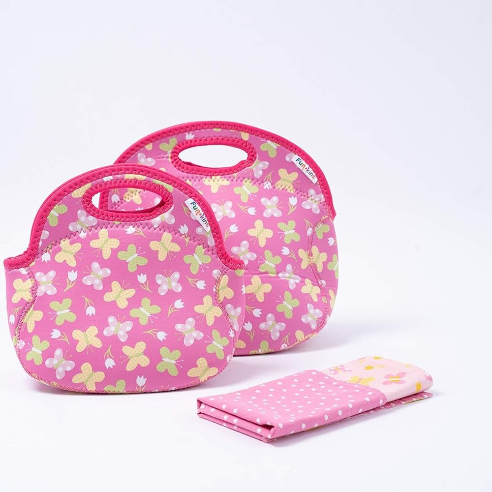 Set of two pink insulated lunch bags with butterfly print and matching pink napkin with white polka dots.