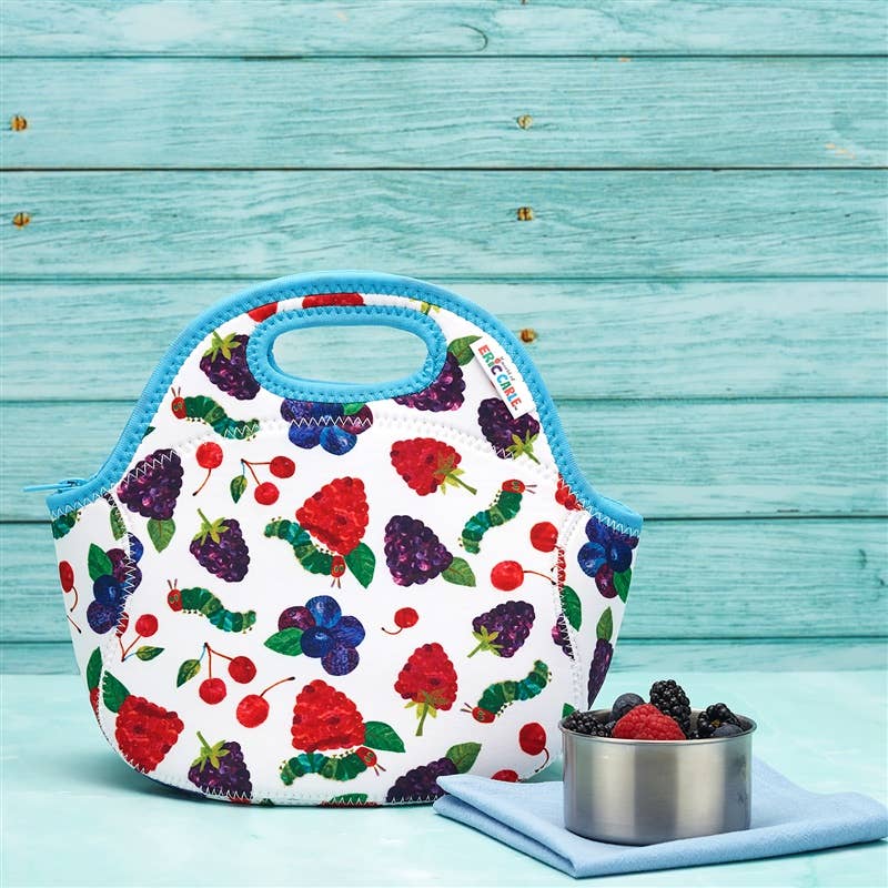 White berry-print lunch bag with bright blue trim and built-in handle, zipper closure, on turquoise wooden backdrop
