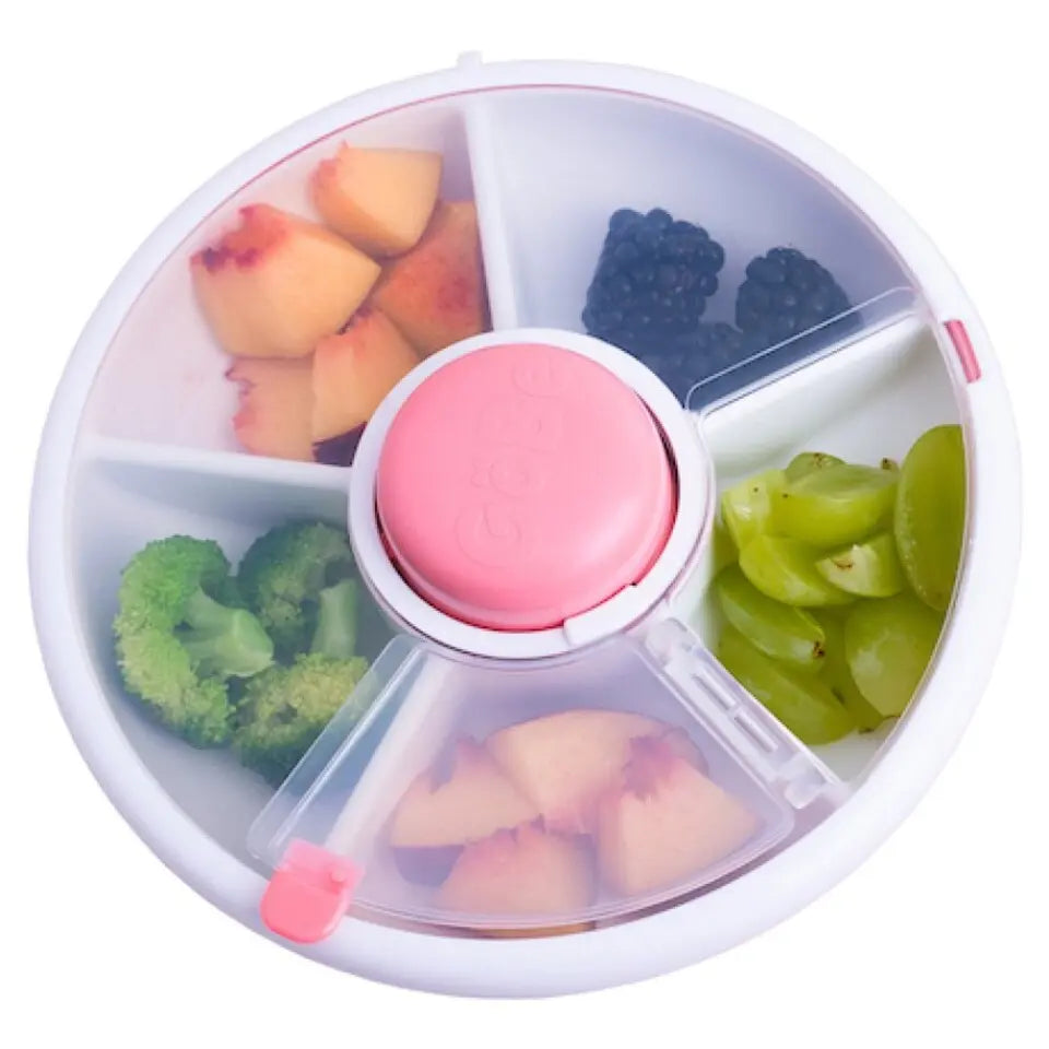 Gobe Snack Spinner Small round lunch box with pink center cap; rotating compartments hold peaches, berries, grapes, broccoli, and pineapple.