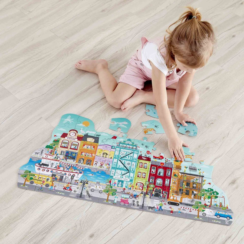 Hape Animated City Puzzle for kids, colorful illustrated interlocking cityscape.
