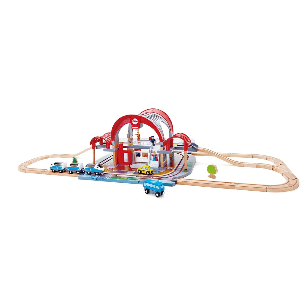 Hape Grand City Station wooden train set with red arches; kids push trains and vehicles along curved tracks.
