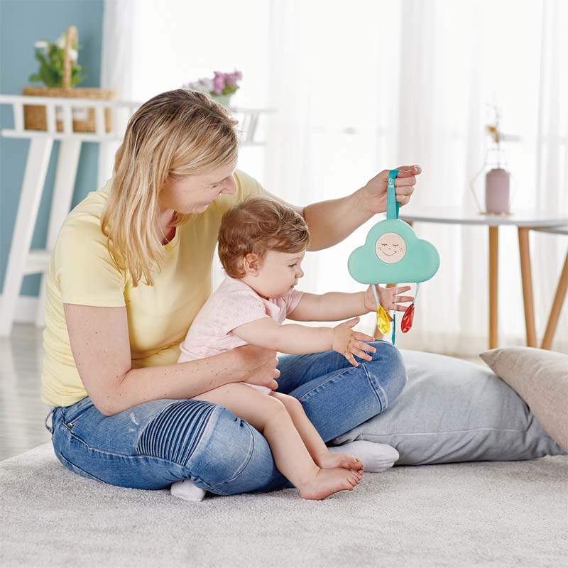 Hape musical cloud light toy, teal cloud with a smiling face and multicolor ribbons for baby play.