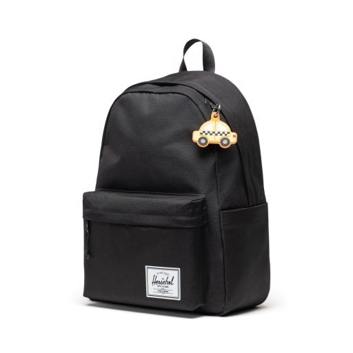 Herschel Taxi Bag Charm in Taxi, shown attached to a black backpack.