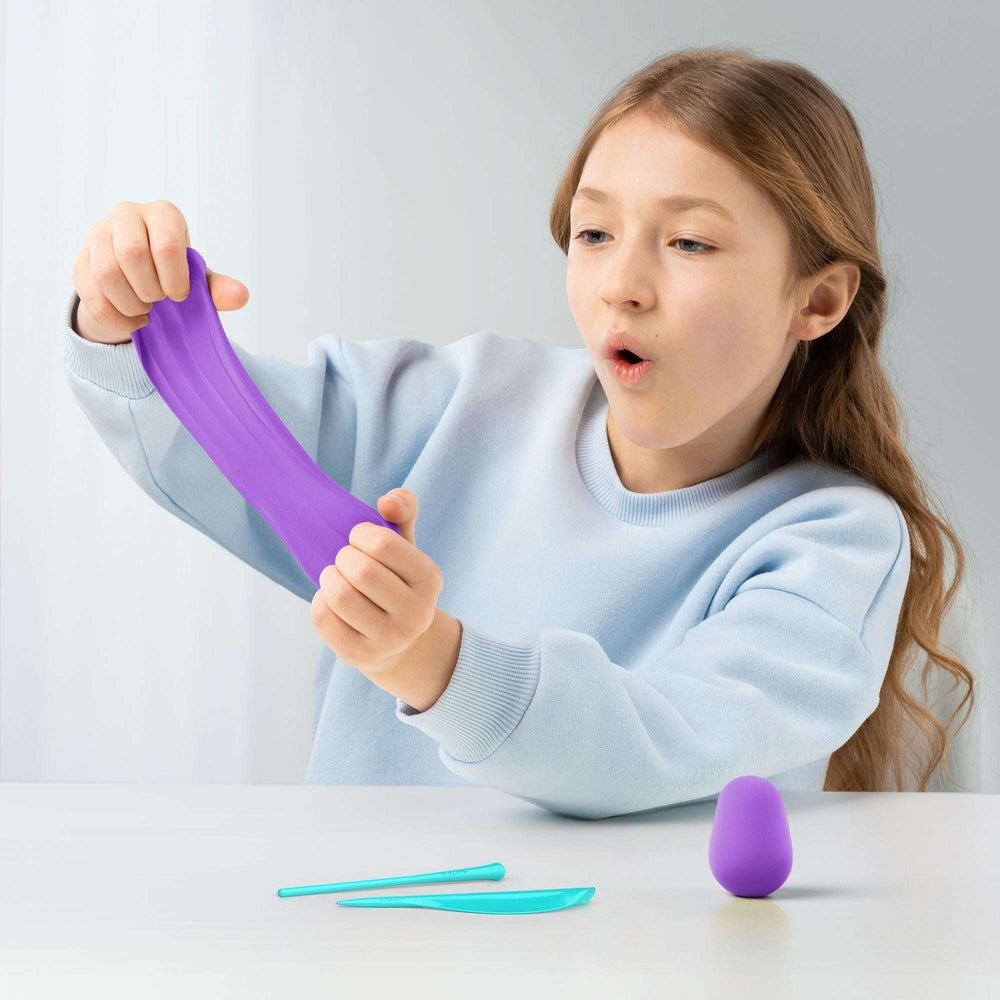 Hey Clay Rainbow Unicorns clay set by HEY CLAY; child stretches purple clay with turquoise sculpting tools.