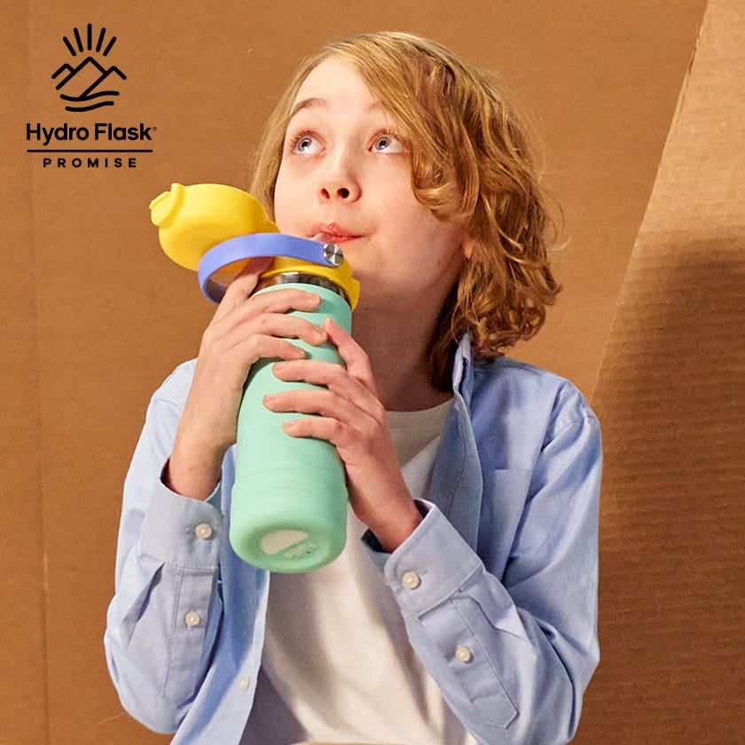 Hydro Flask Kids 18 oz Wide Mouth Bottle With Covered Straw Cap And Boot – Lifetime warranty – child drinking from bottle with warranty graphic
