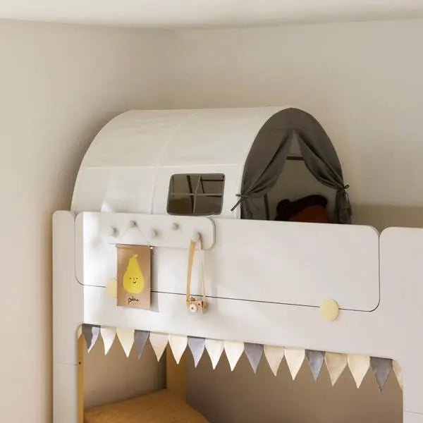 Iloom Cabin Kids Tent perched on a white loft bed, with grey curtains draped at the entrance and triangle bunting along the rail.