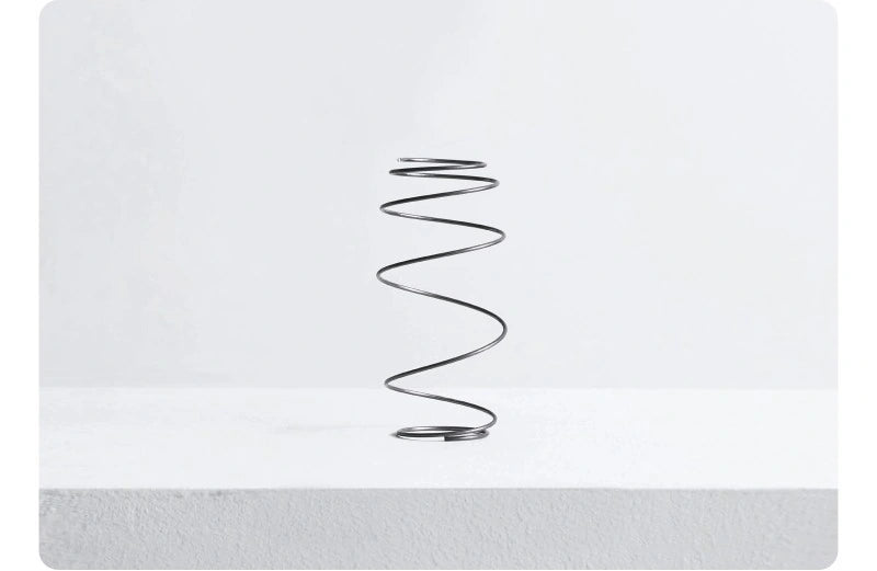 An upright steel coil against a pale grey background, illustrating the manufacturer’s spring design for Daily Kids.