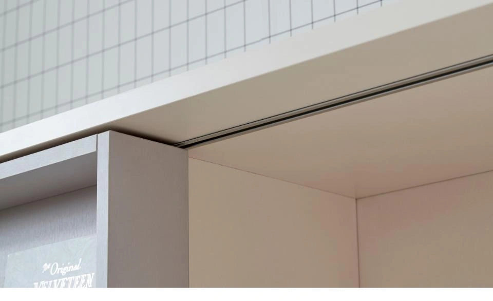 Full close-up of the aluminum sliding rail beneath the bookcase upper panel.