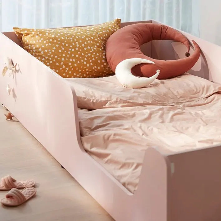 ILOOM Eddi Kids Low Bed 1100W in pale pink with crescent-moon pillow and mustard polka-dot cushion.