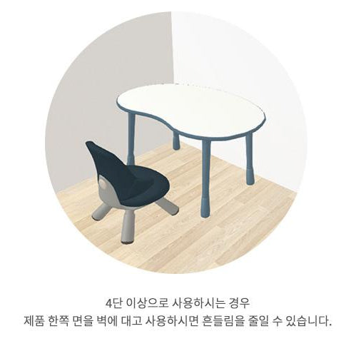 ILOOM Growing Desk Peanut 1200W with white oval tabletop and blue legs beside a dark chair on a wooden floor.