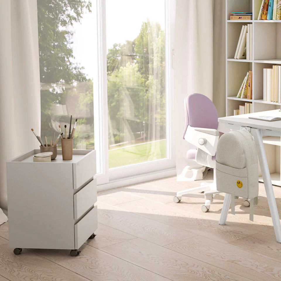Iloom Roy Mono Desk Drawer white three-drawer cabinet on casters beside a lavender desk chair in a bright study