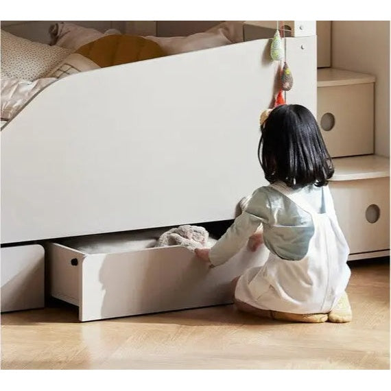 Iloom Tinkle Pop 1 Story Bed in white with an open under-bed drawer, as a toddler pulls out the storage.