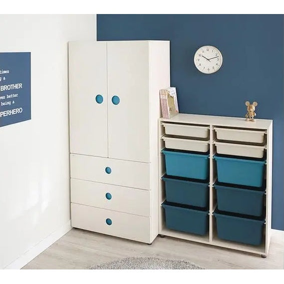 Iloom Tinkle Pop 3 Drawer Dresser 800W, white with blue knobs, beside blue storage bins in cubby shelves.