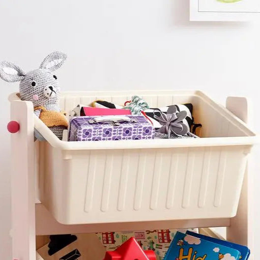 ILoom Tinkle Pop Kids Play Storage bin, cream plastic on a white shelf, filled with toys and a plush bunny.